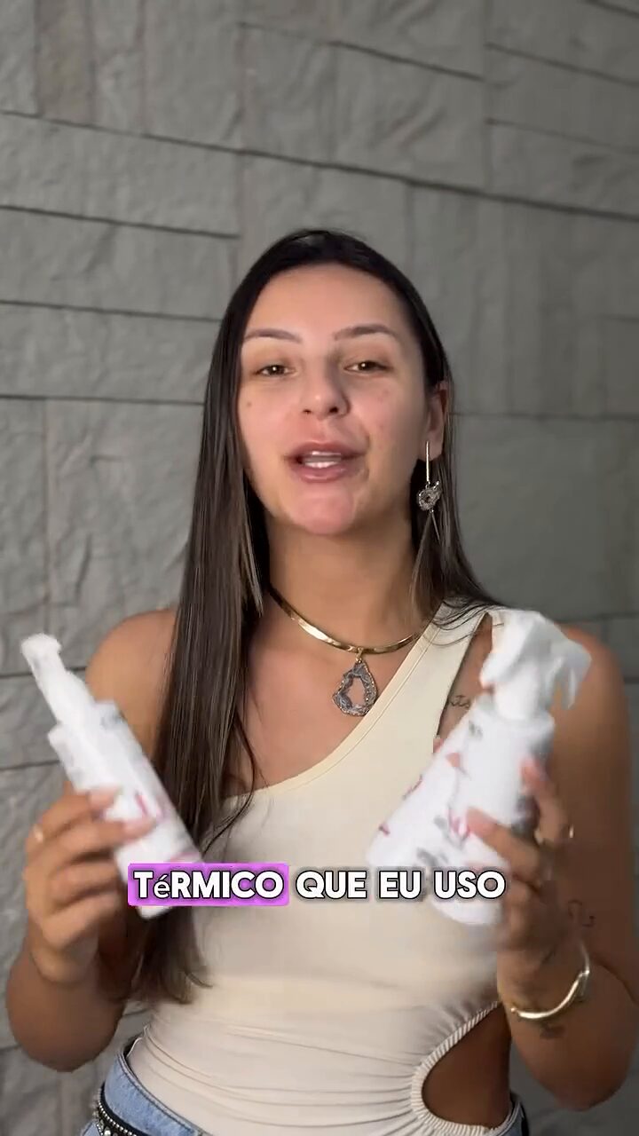 Vitória segurando frascos de um protetor térmico capilar, falando para a câmera.